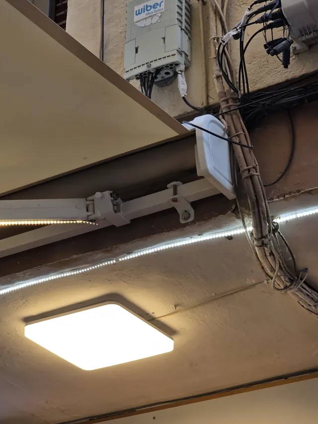 Tira LED y plafón instalados en el techo de un local