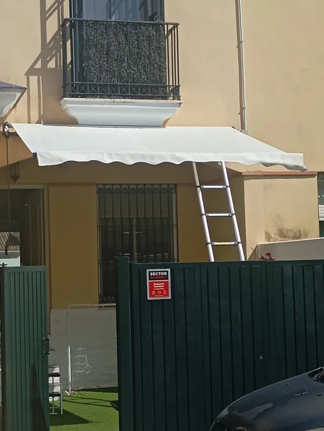 Toldo blanco instalado en la fachada de una vivienda